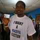 Man displays his voter's card and wears a t-shirt with the inscription ' i want a peaceful election '